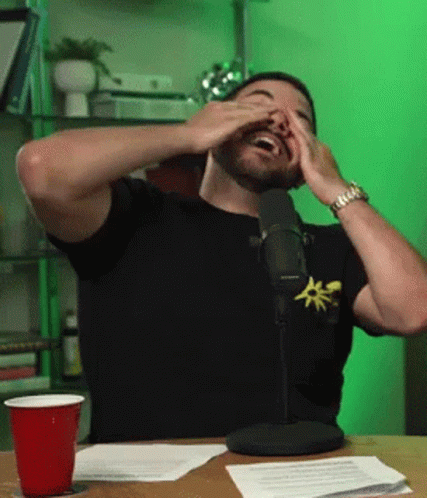 Man Covering Eyes While Sitting At Microphone GIF