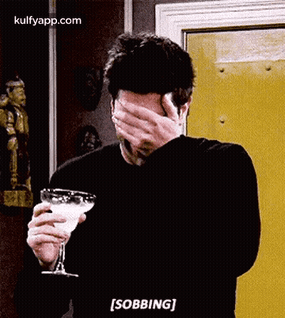 Man Covering Face Holding Martini Glass Saying Sobbing GIF
