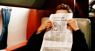 Man Covering Face With Newspaper Saying Cellular Phone