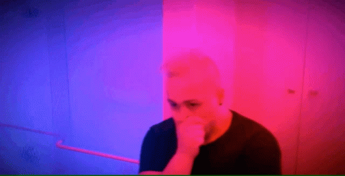 Man Covering Mouth In Front Of Pink And Blue Background GIF