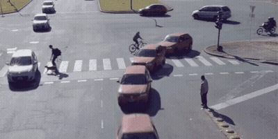 Man Crossing Street As Cyclist Rides By GIF