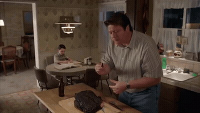 Man Cutting Meat On Board GIF