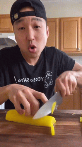 Man Cutting Yellow Item With Knife GIF