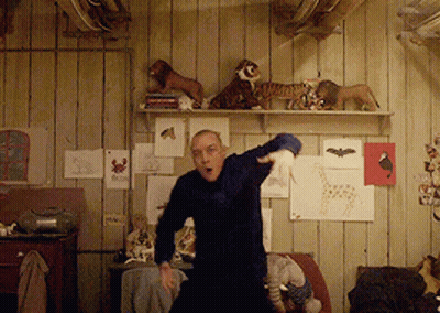 Man Dancing Among Stuffed Animals On Wall GIF