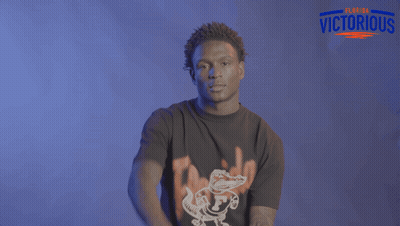Man Dancing In Front Of Clemson Logo Brick Wall GIF
