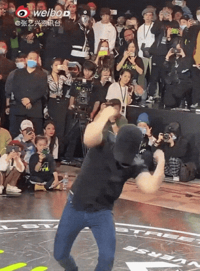 Man Dancing In Front Of Crowd With Weibo Logo GIF