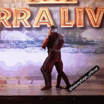 Man Dancing On Stage In Front Of Rraliv Sign GIF