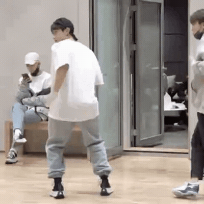 Man Dancing While Another Man Sits On Bench Looking At Phone GIF