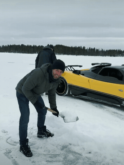 Man Digging In Snow Near Yellow Car GIF