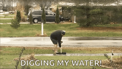Man Digging Water With Shovel While Wearing Shorts GIF