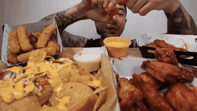 Man Dipping Chicken Wing In Yellow Sauce GIF
