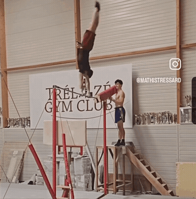 Man Doing Handstand In Front Of Gym Banner GIF