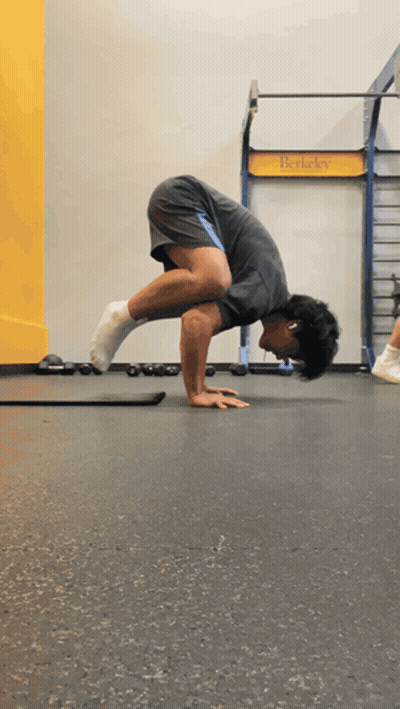 Man Doing Handstand In Front Of T-Rex Sign GIF