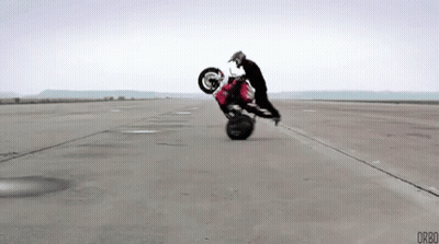 Man Doing Motorcycle Trick On Empty Road GIF