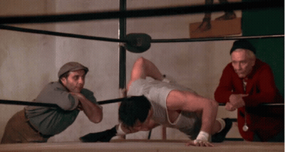 Man Doing Push Ups in Boxing Ring with Watcher