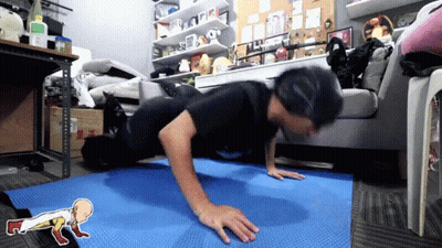 Man Doing Push Ups On Blue Mat In Front Of Couch GIF