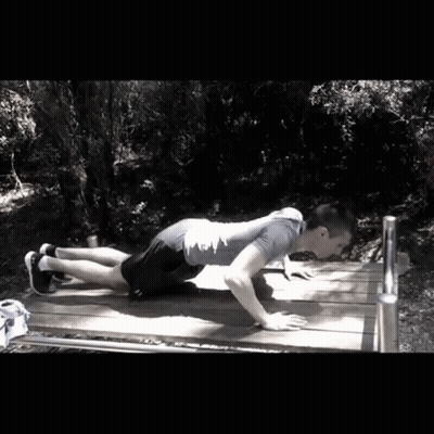 Man Doing Push Ups On Wooden Bench In Woods GIF