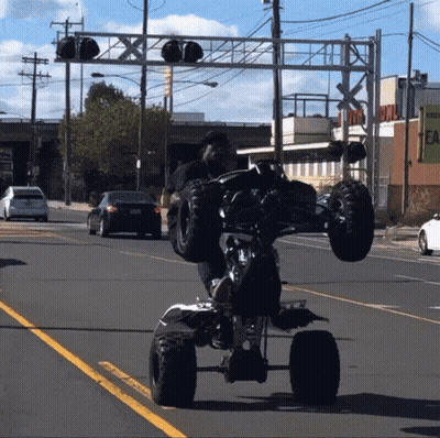 Man Doing Trick On ATV On Street GIF