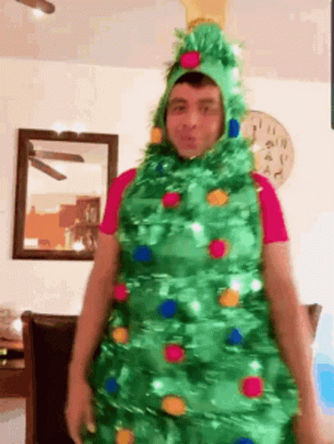 Man Dressed As Christmas Tree In Living Room GIF