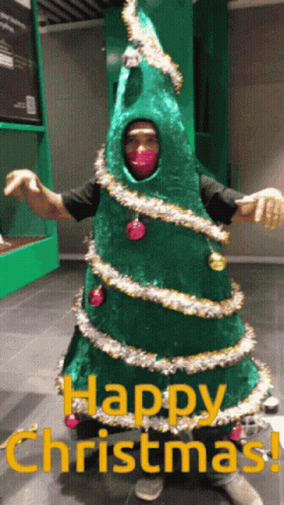 Man Dressed As Christmas Tree Saying Happy Christmas GIF