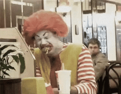 Man Dressed As McDonald's Clown Eating Hamburger GIF
