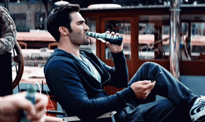 Man Drinking Bottle Holding Cell Phone GIF