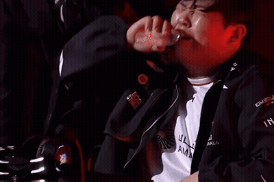 Man Drinking Bottle In Dark Room With Another Watching GIF