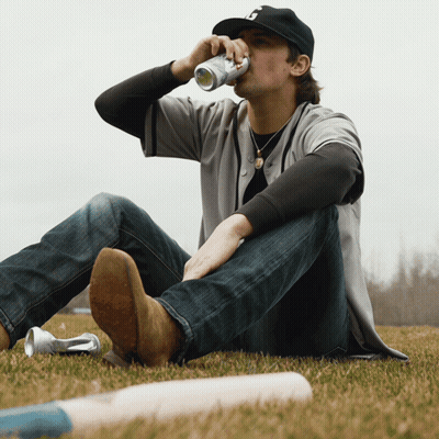 Man Drinking Can With B On Grass GIF