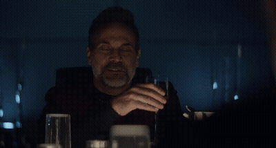 Man Drinking From Glass In Front Of 70 Sign GIF