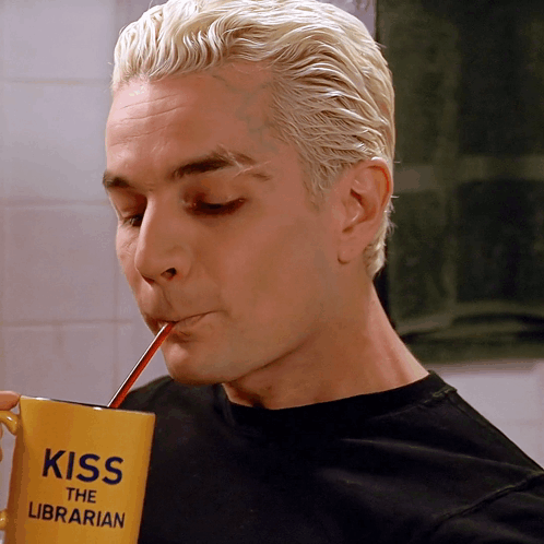 Man Drinking From Yellow Cup Saying Kiss The Librarian GIF