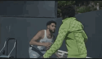 Man Drinking Water From Plastic Bottle Next To Another Man On Park Bench GIF