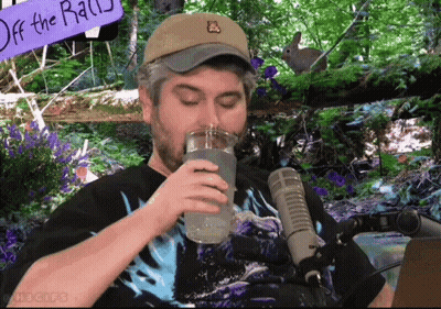 Man Drinking Water In Front Of Off The Rail Sign GIF