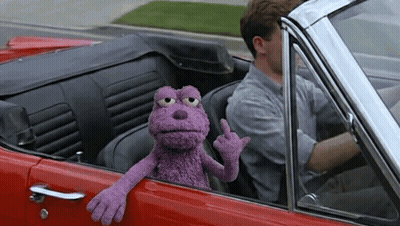 Man Driving Red Car With Purple Puppet GIF