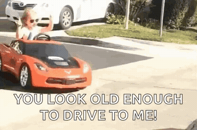 Man Driving Red Toy Car On Street GIF