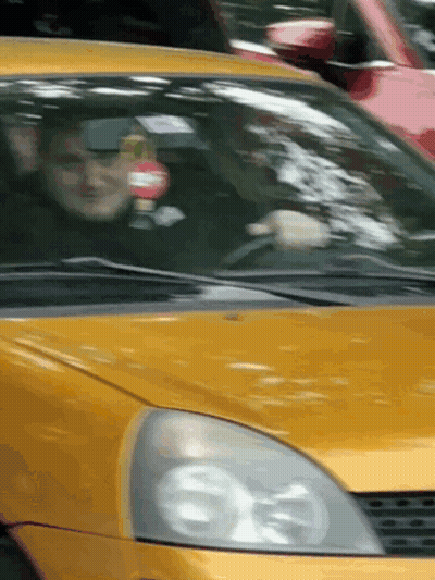 Man Driving Yellow Car With Red And White Sign GIF