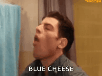 Man Eating Blue Cheese in Bathroom