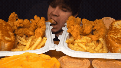 Man Eating Chicken And Fries In Plastic Containers GIF
