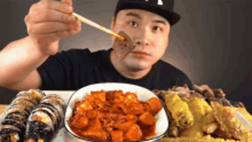 Man Eating Food With Chopsticks In NY Hat GIF