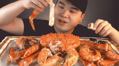 Man Eating Large Crab and Shrimp