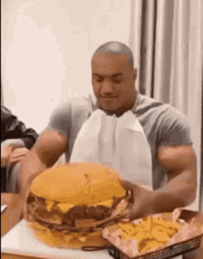 Man Eating Large Hamburger And French Fries GIF