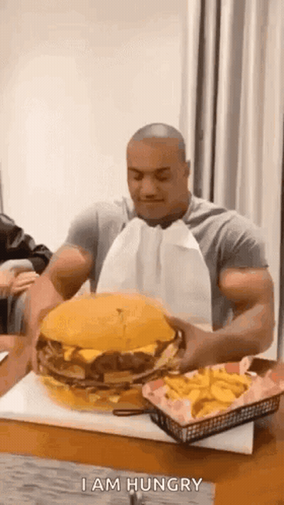 Man Eating Large Hamburger And French Fries GIF