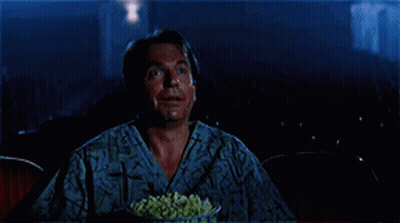 Man Eating Popcorn And Smiling In Theater GIF