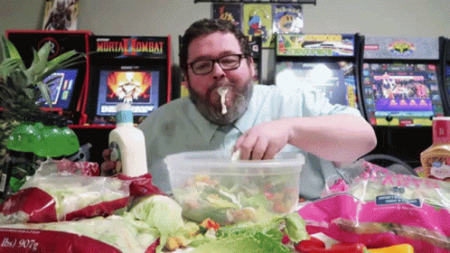 Man Eating Salad In Front Of Mortal Kombat Machine GIF