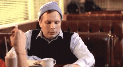 Man Eating Sandwich And Drinking Milkshake In Diner GIF