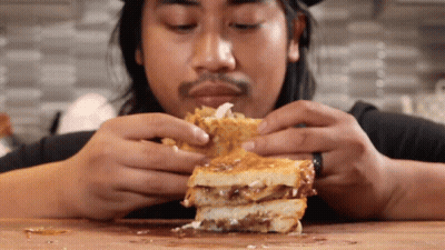 Man Eating Sandwich With Toppings