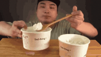 Man Eating Two Cups Ice Cream With Wooden Spoon GIF