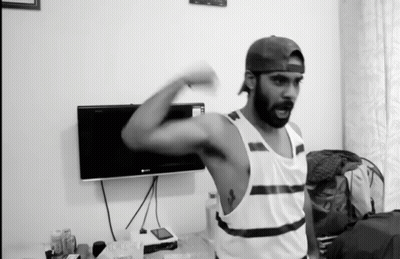 Man Flexing Muscles In Front Of TV GIF