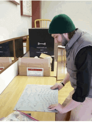 Man Folding Completed Jigsaw Puzzle GIF