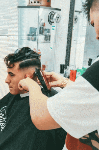 Man Getting Haircut by Barber Wearing LG Shirt