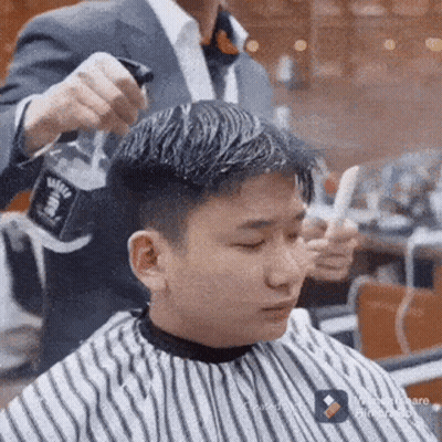 Man Getting Haircut In Striped Cape At Barber GIF
